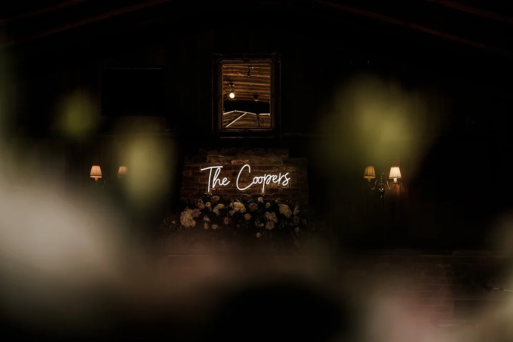 The Coopers neon sign glowing in the barn at Willow Marsh Farm