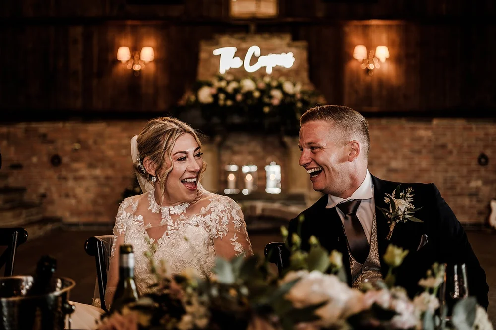 Lauren and Tom laughing during the wedding speeches at Willow Marsh Farm