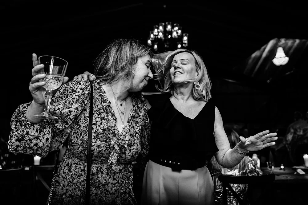 Black and white photograph of two guests laughing during the evening