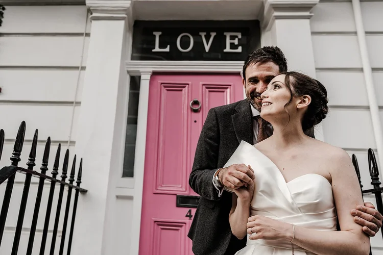 Michelle and Robin outside a pink door on a Chelsea street