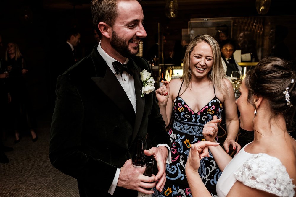 The groom laughing with guests during the drinks reception at Fortnum & Mason