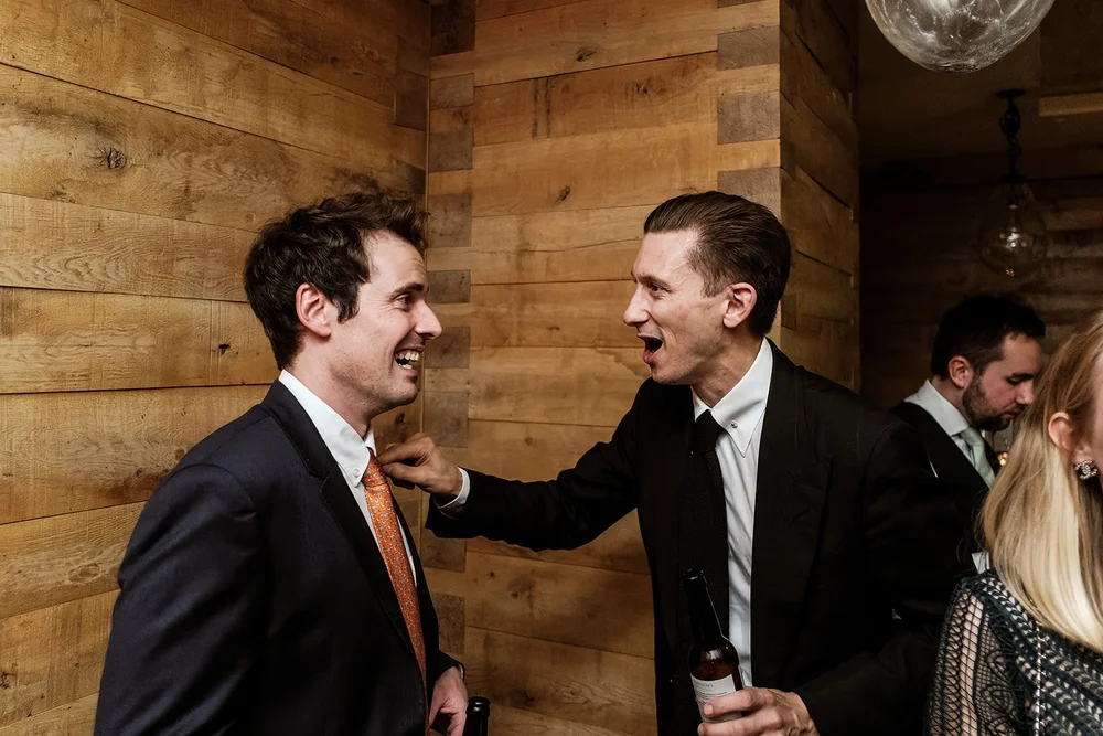 Two guests laughing together during the reception
