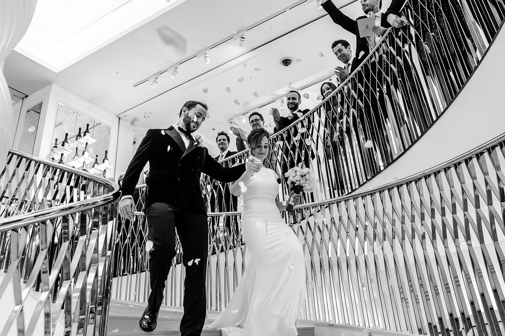 Black and white photograph of the couple on the spiral staircase at Fortnum & Mason