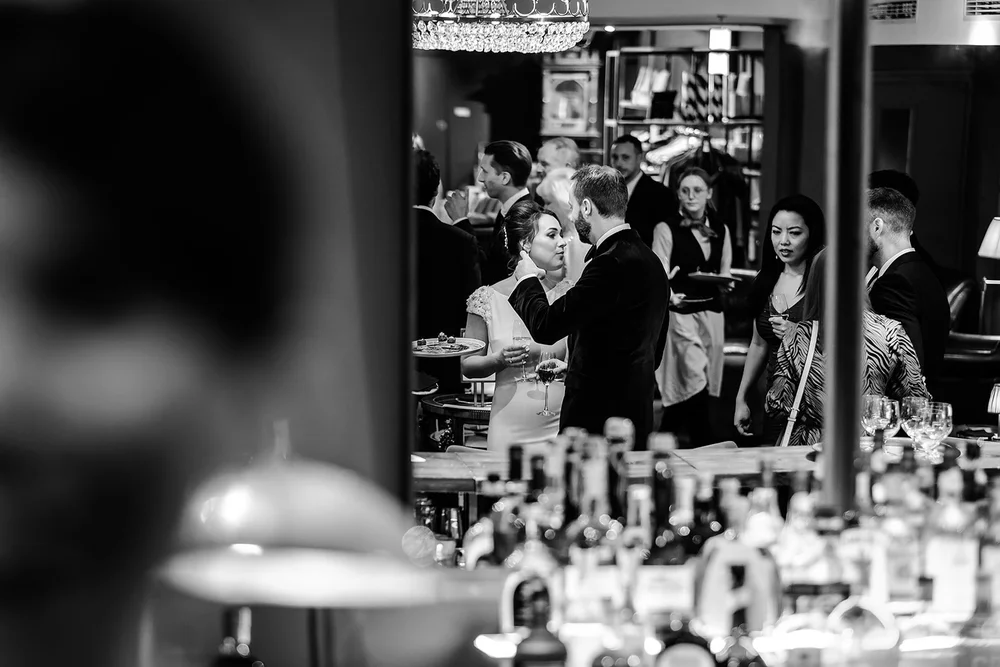 Black and white photograph of guests at the bar during the evening