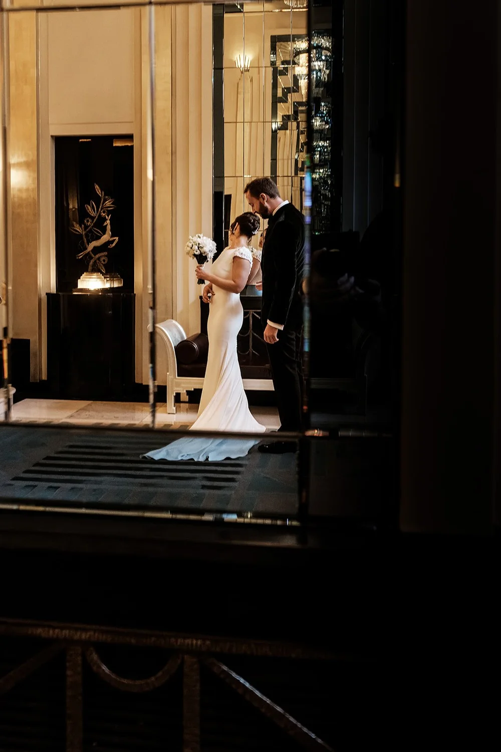 The couple reflected in the mirrored hallway at Claridge&rsquo;s
