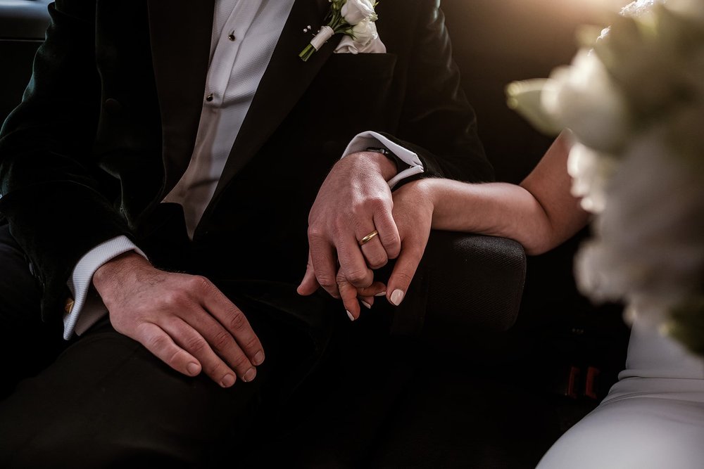 Black and white detail of the couple holding hands with the bridal bouquet