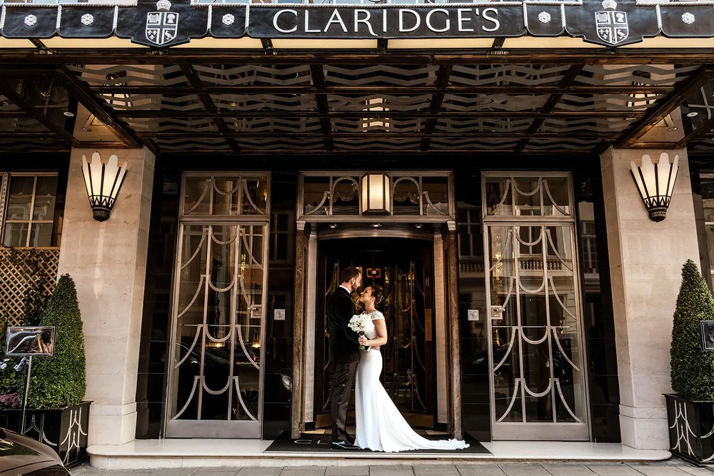 The bride standing beneath the Claridge&rsquo;s entrance canopy in Mayfair