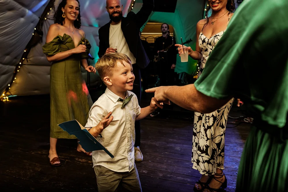 A child dancing with the guests under the coloured lights in the tipi