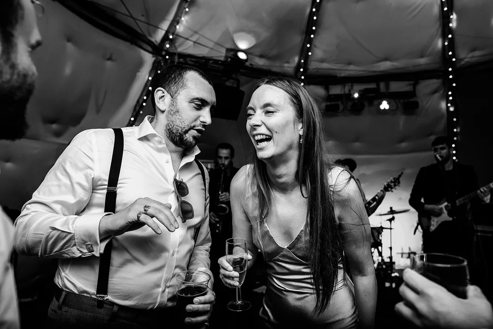 Black and white photograph of guests dancing in the tipi