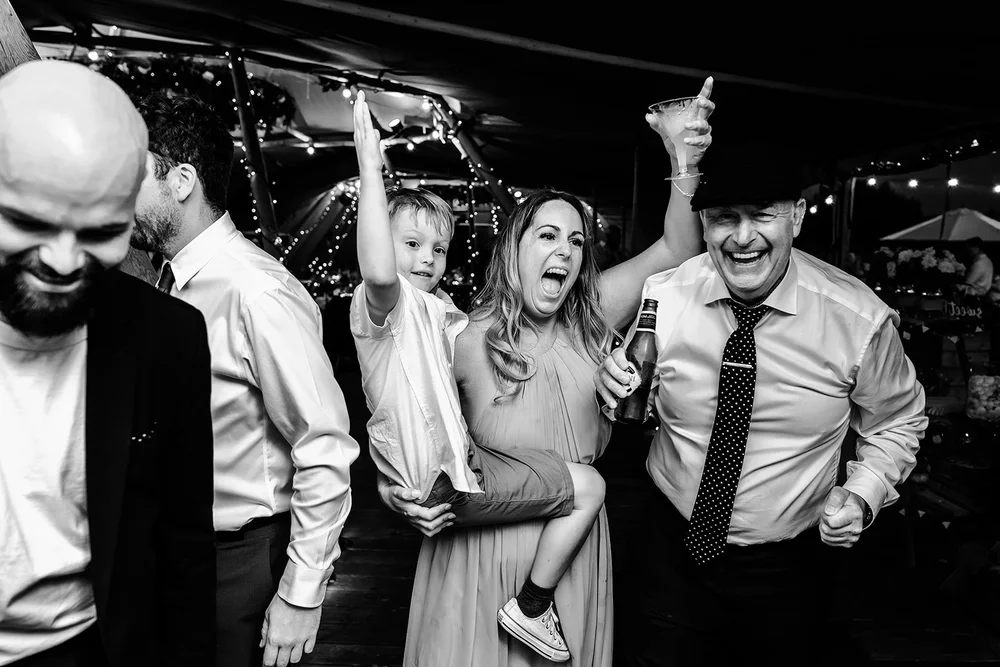 Black and white photograph of guests dancing at the end of the night