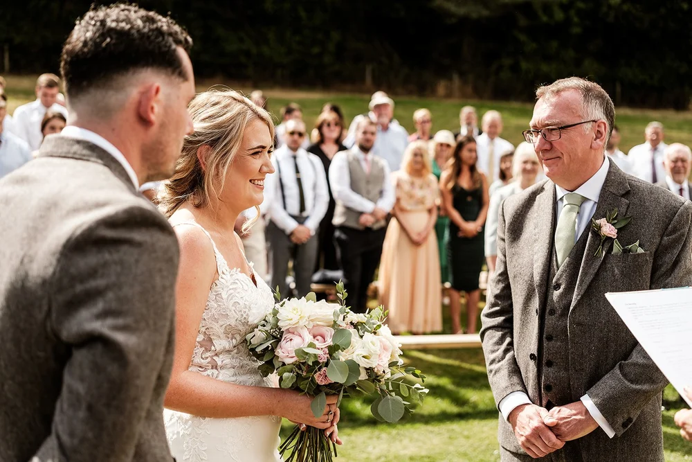 Liv walking down the outdoor aisle with her father at Hadsham Farm