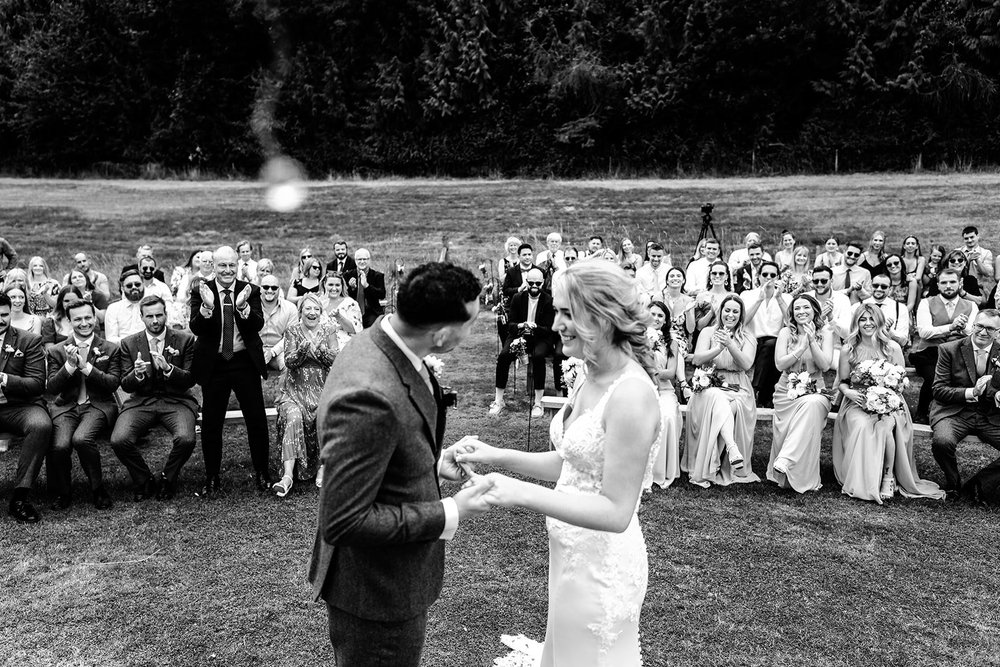 Black and white photograph of Liv and Jack walking back through their guests