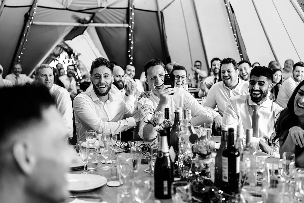 Black and white photograph of guests around the table inside the tipi at Hadsham Farm