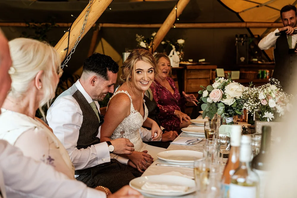 Guests along the table during the wedding breakfast in the tipi
