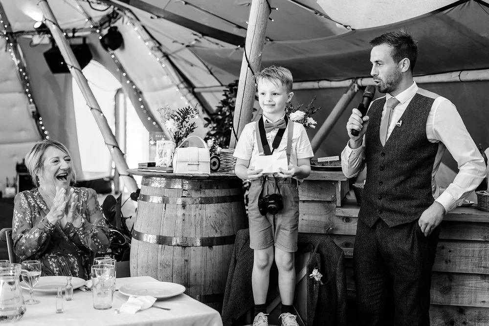 Black and white photograph of guests laughing during the speeches