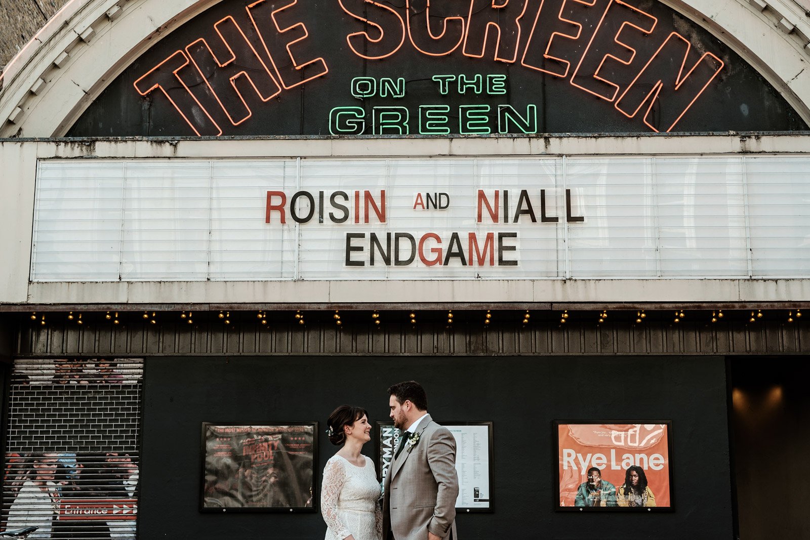 Roisin and Niall outside the Screen on the Green cinema in Islington, their names on the marquee above them