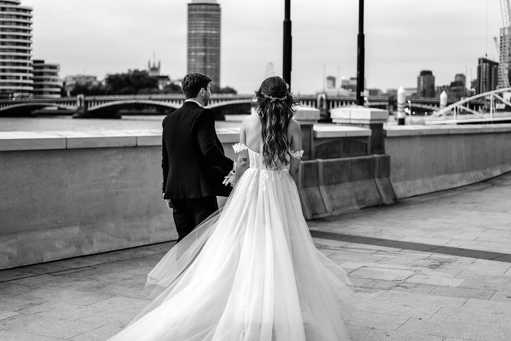 Bride and groom on the Embankment by the river after a Chelsea Old Town Hall wedding