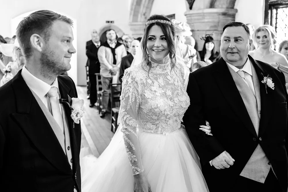 Black and white photograph of Jade and Guy at the front of the Norman chapel at Farnham Castle