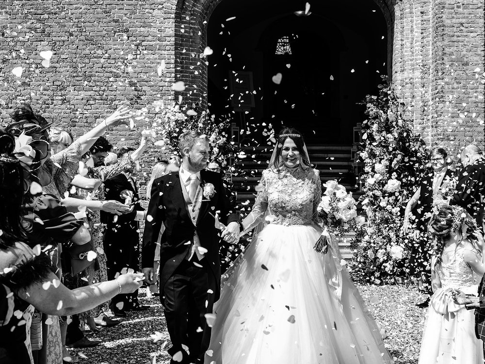 Black and white photograph of confetti thrown over Jade and Guy at Farnham Castle