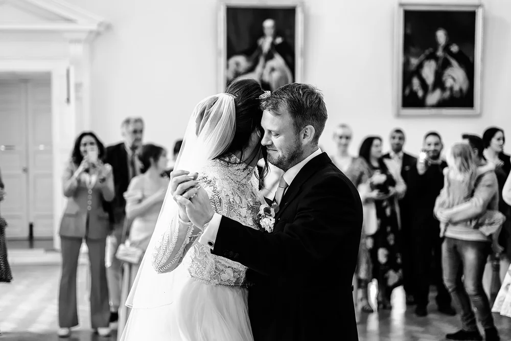 Black and white photograph of Jade and Guy dancing with guests around them