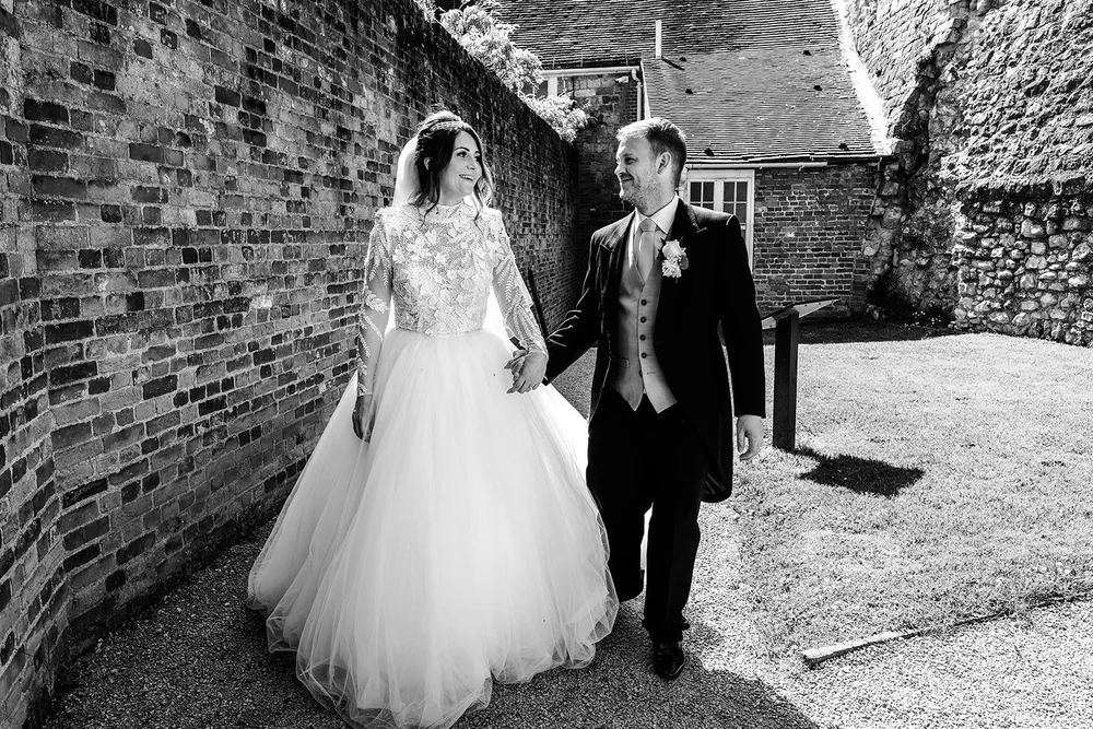 Black and white photograph of Jade and Guy walking through the castle grounds