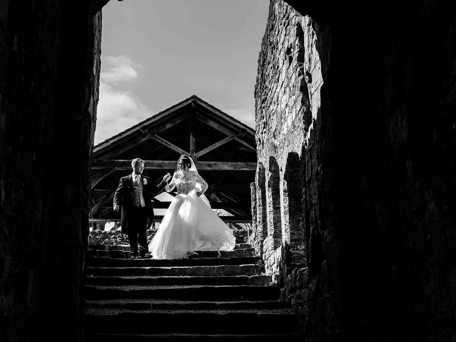Black and white photograph of Jade framed in the stone gateway at Farnham Castle