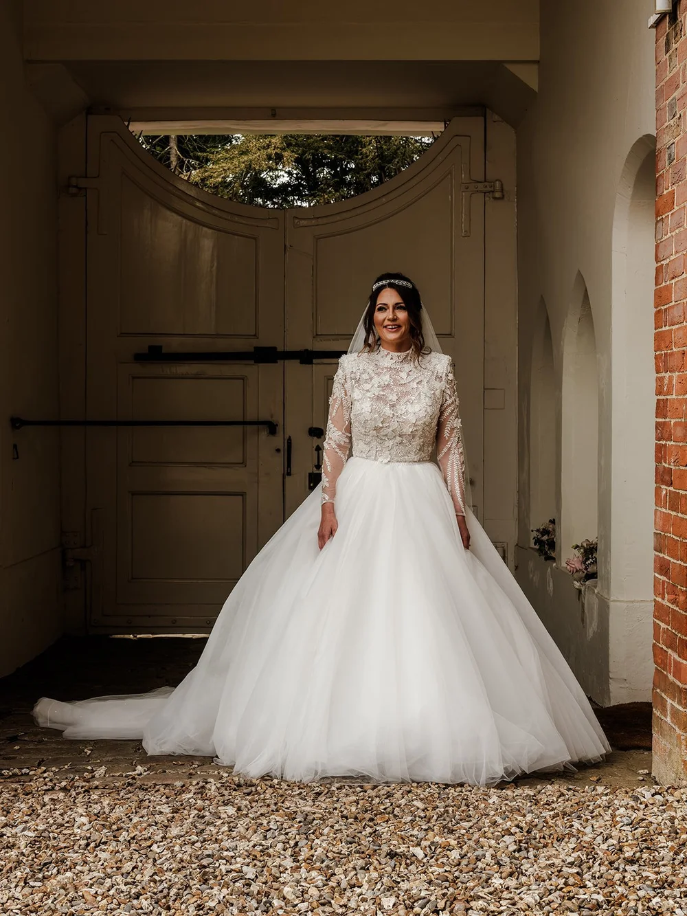 Jade in her ballgown wedding dress in the doorway at Farnham Castle