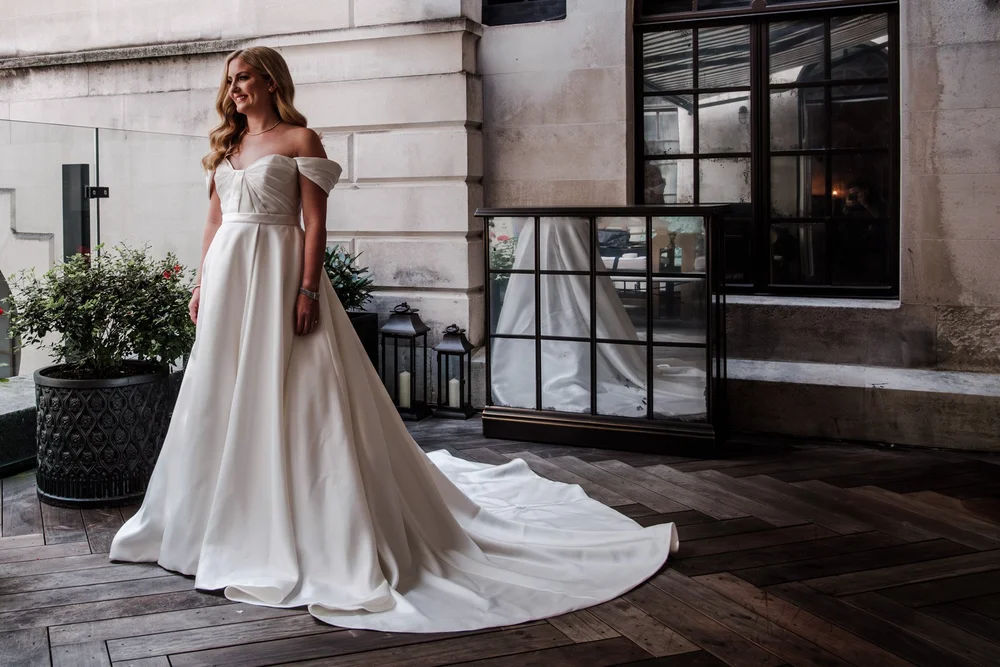 Bride and groom on the rooftop terrace with London views behind them