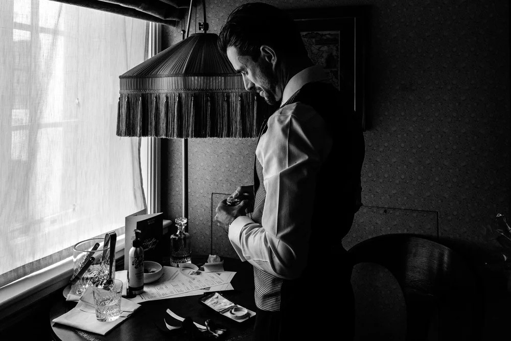 Groom getting ready in one of the beautifully appointed rooms at The Ned Hotel