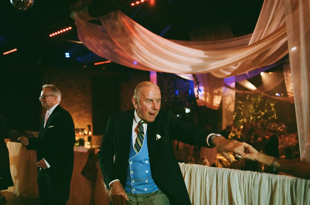 Wedding guests dancing under coloured light, shot on 35mm colour film