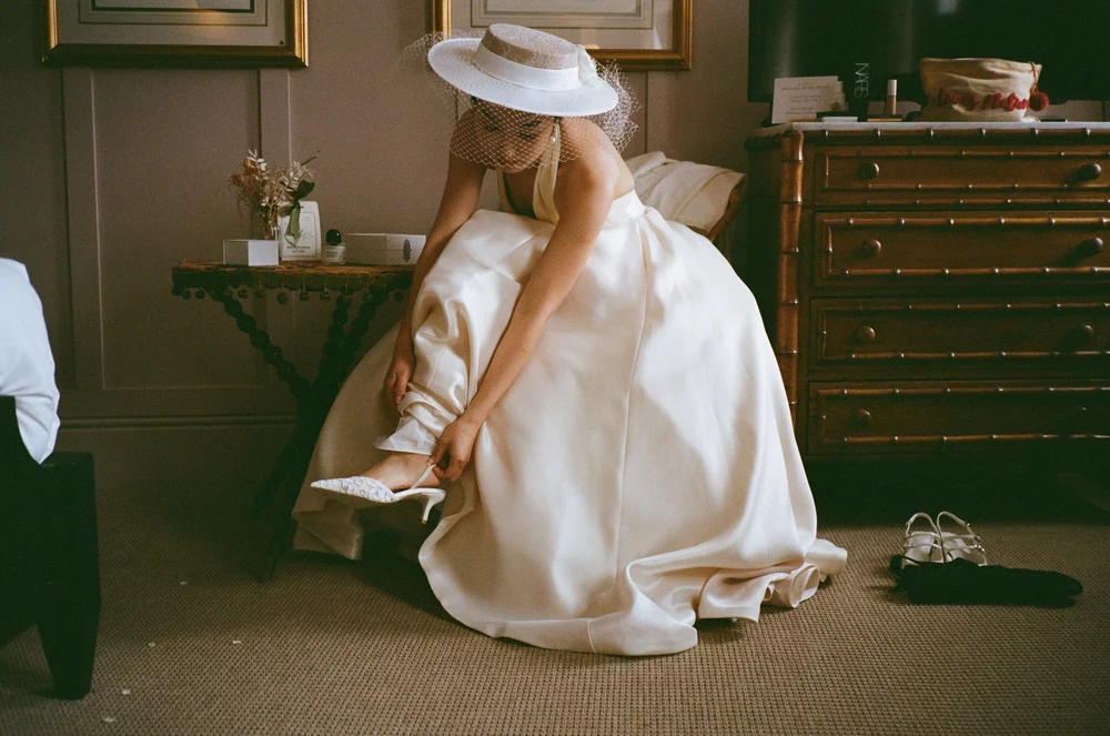 Bride sitting in a panelled room in her wedding dress, shot on 35mm colour film