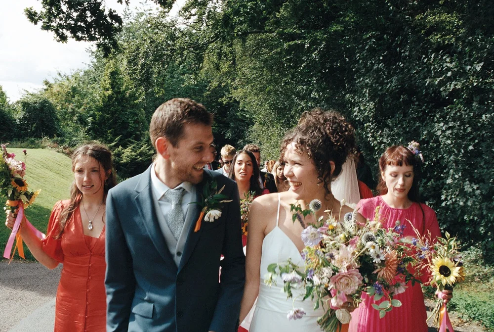 Bride and groom with guests and bouquets outdoors, photographed on Kodak Portra 400