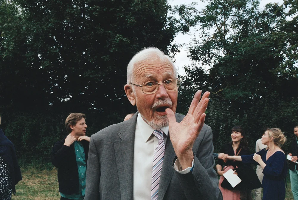 A wedding guest applauding outdoors, shot on 35mm film