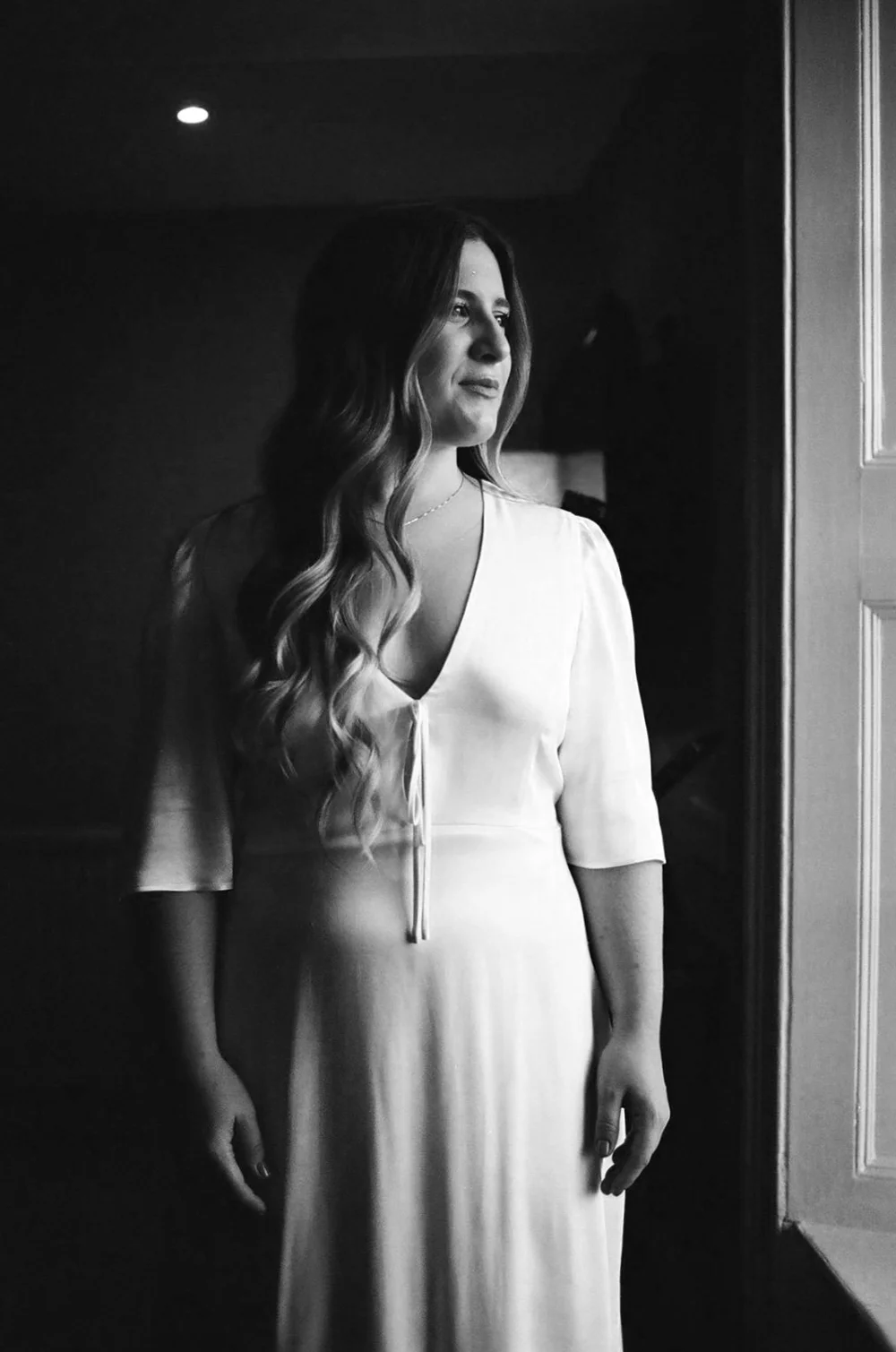 Bride in window light photographed on 35mm black and white film
