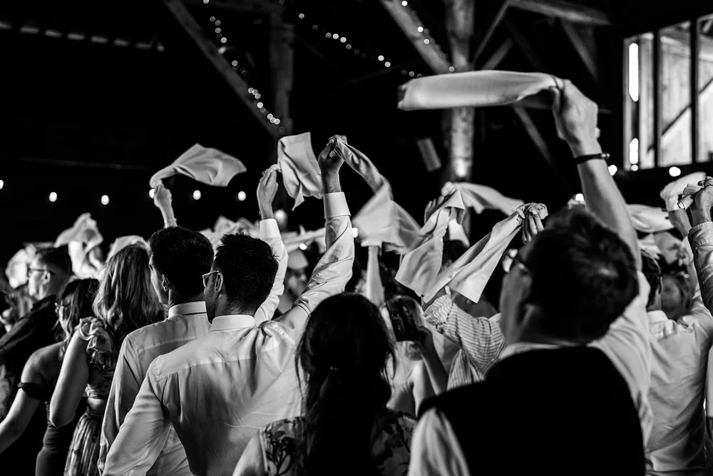 Guests waving napkins above their heads in the barn at Elmley