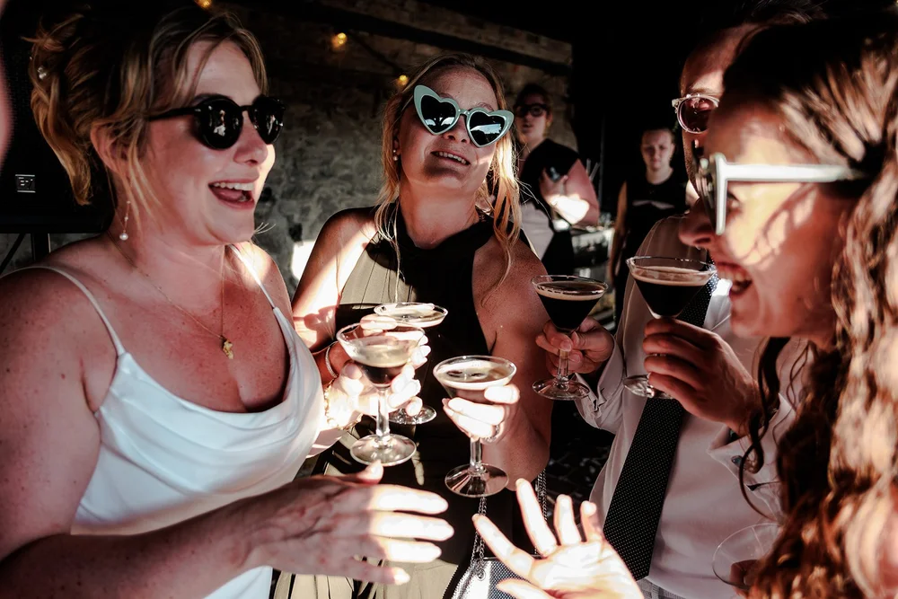 Guests toasting with coupes at Rose and Frankie&rsquo;s Kent wedding