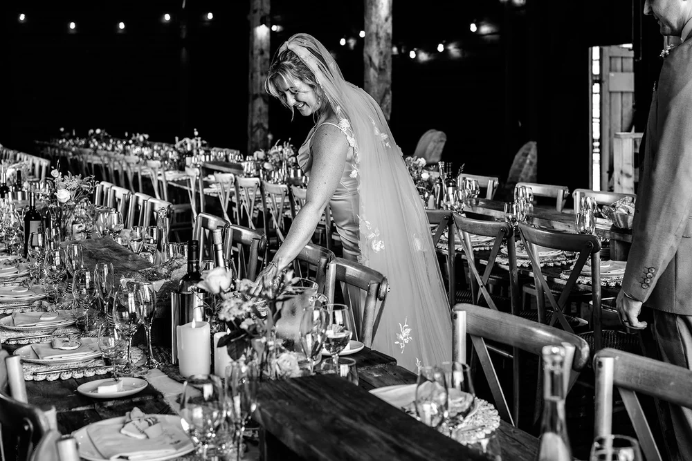 Rose leaning over the candlelit table in the barn at Elmley