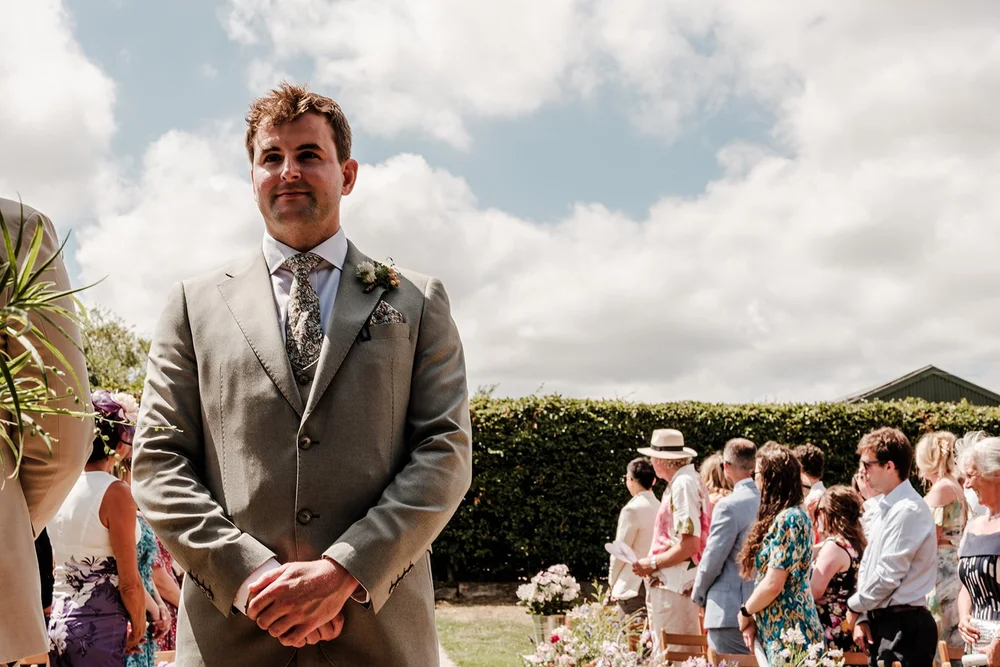 Frankie waiting at the front of the outdoor ceremony under a big Kent sky