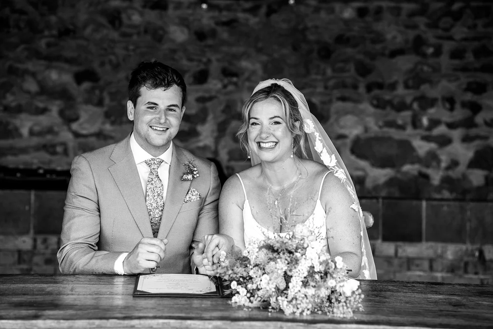 Rose and Frankie signing the register against the flint wall at Elmley