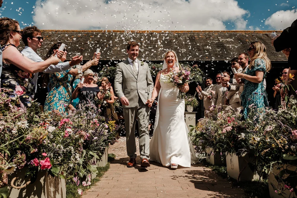 Confetti as Rose and Frankie walk back through their guests at Elmley