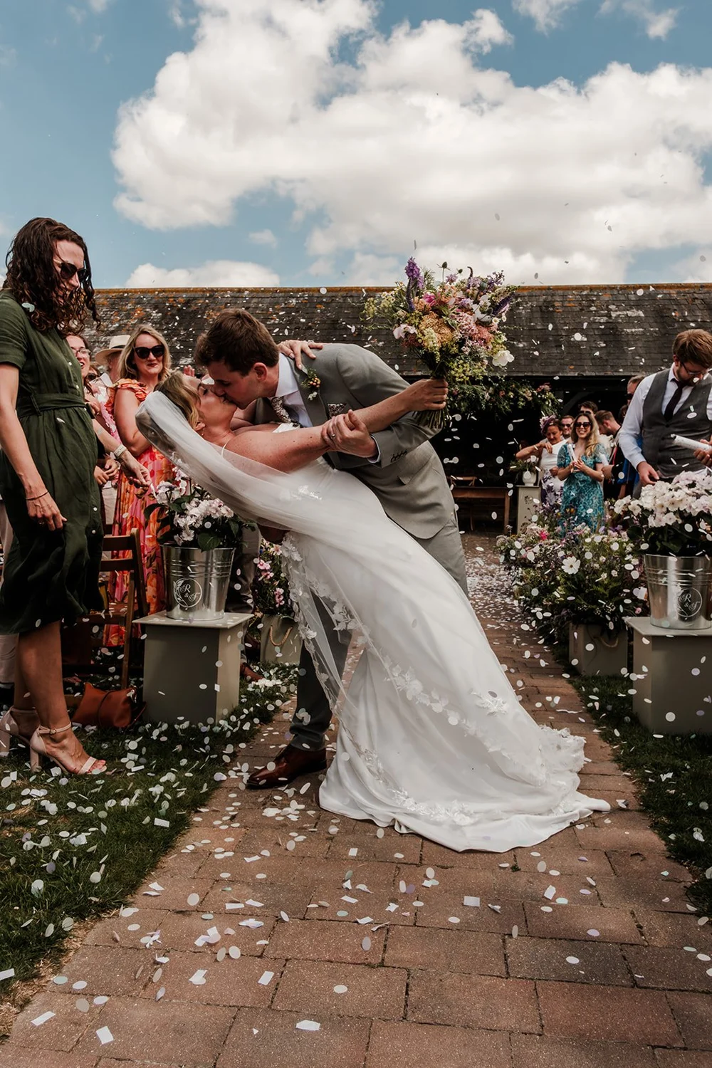 Rose and Frankie kissing in a confetti shower after the ceremony