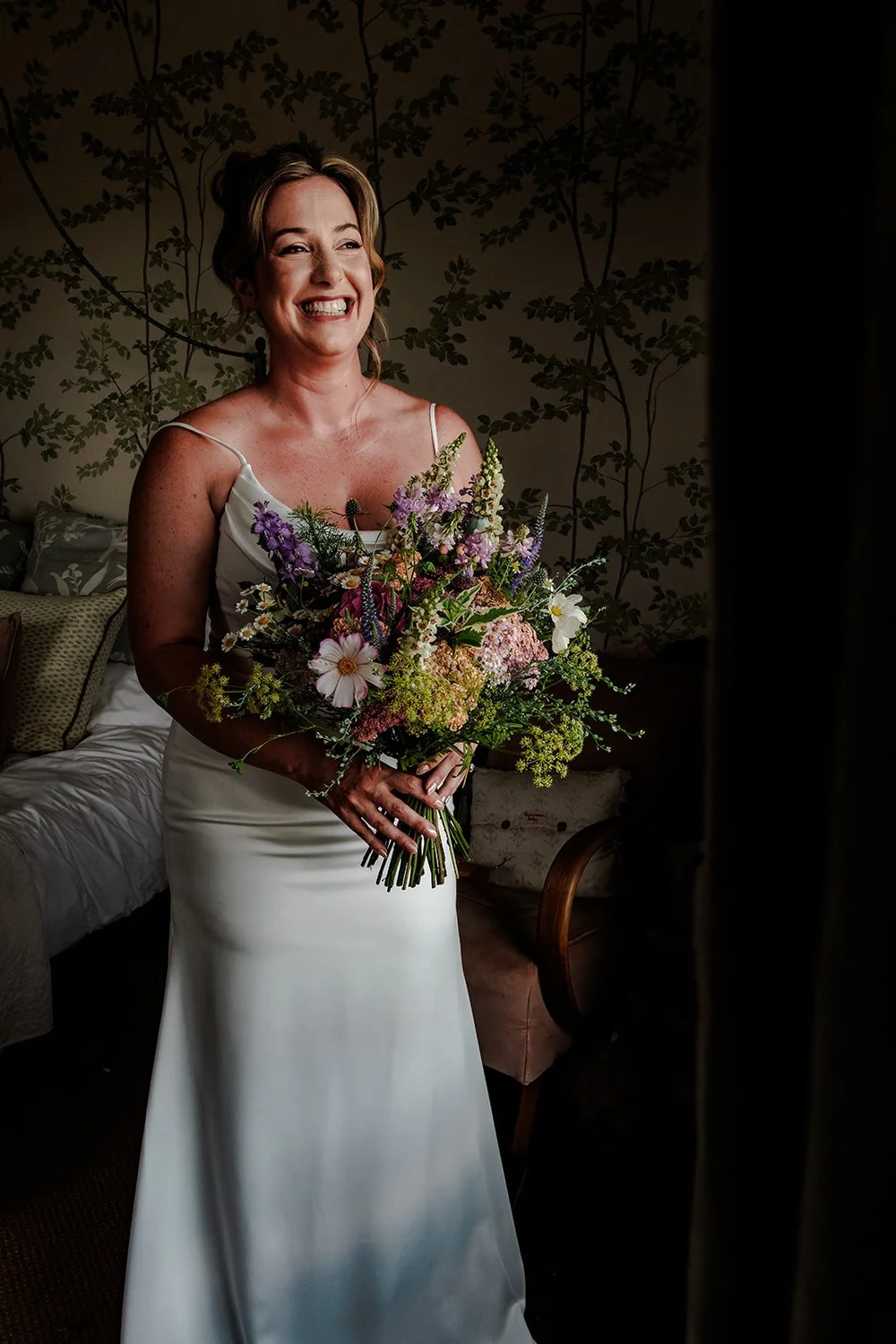 Rose in her wedding dress holding her wildflower bouquet