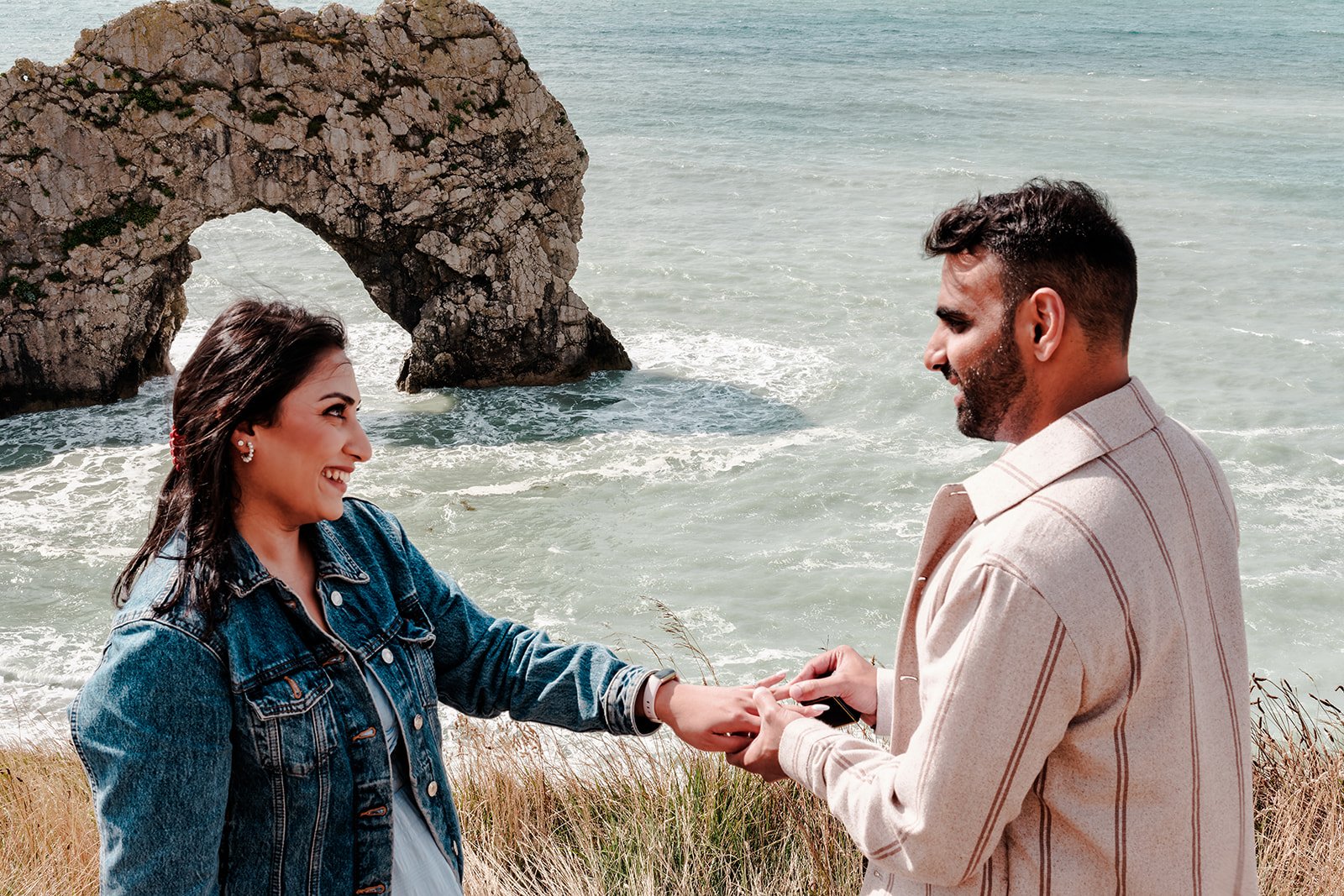 A surprise proposal photographed at Durdle Door by documentary photographer Oliver Holder