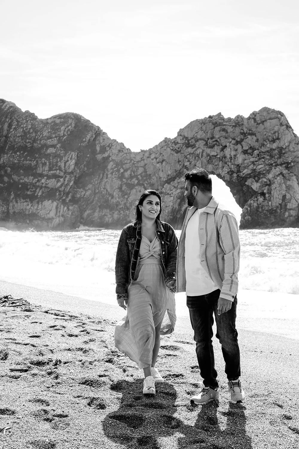 Newly engaged couple beneath the arch at Durdle Door