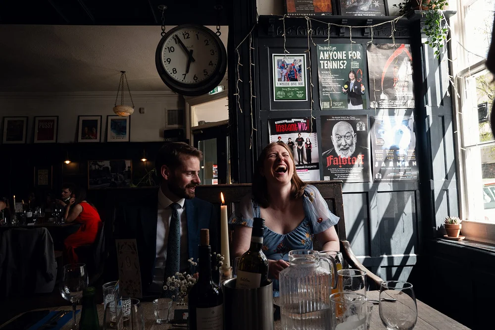 Guests laughing over a drink at the Alma Tavern, Clifton