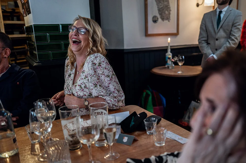 A guest laughing during the wedding speeches at the Alma Tavern