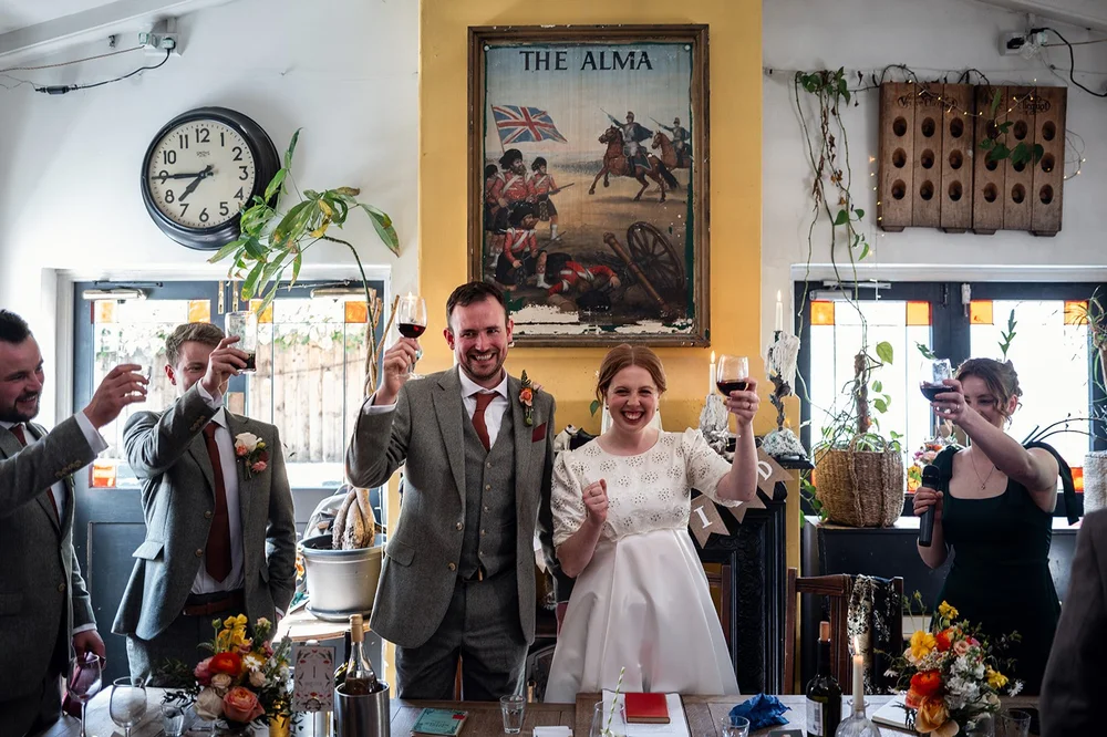 Ffion and Tom raising a glass at their Alma Tavern wedding breakfast