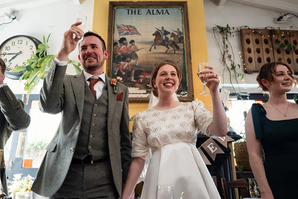 Ffion and Tom cheering during the toast at the Alma Tavern, Bristol