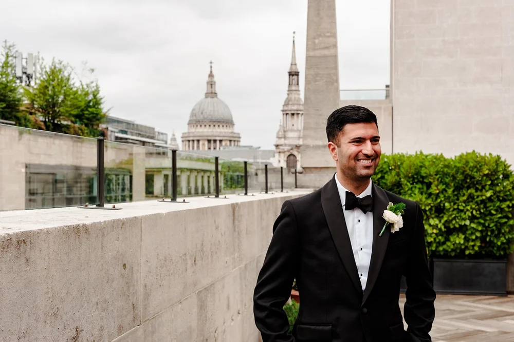 Groom on the roof terrace at The Ned with the dome of St Paul&rsquo;s Cathedral behind him
