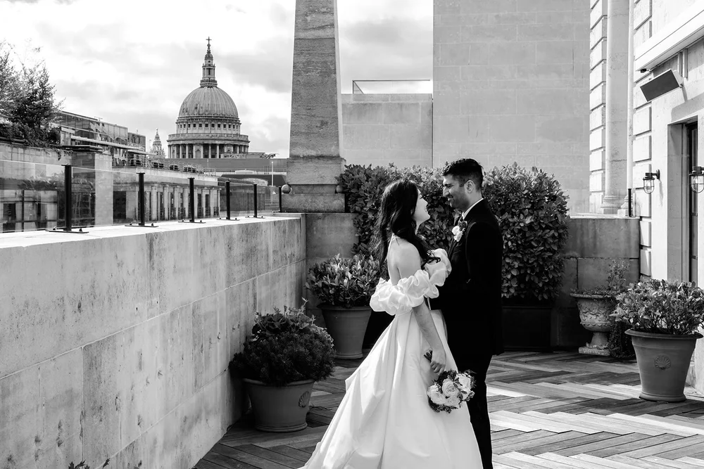 Black and white portrait of a couple on the terrace at The Ned below St Paul&rsquo;s Cathedral